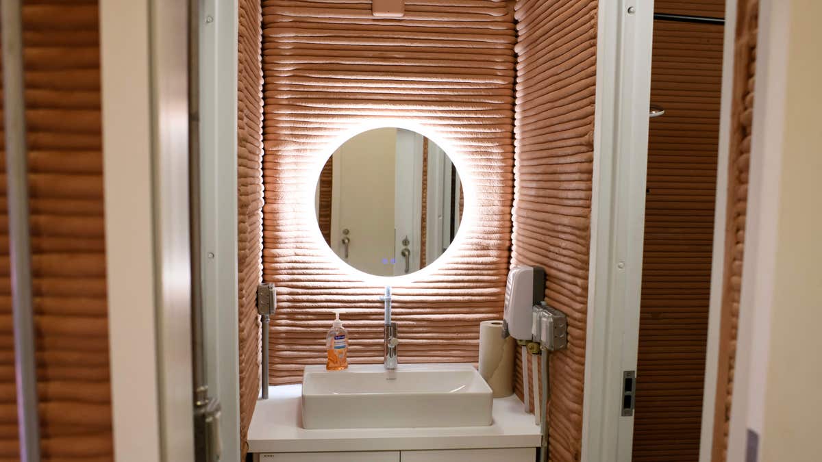 Bathroom of the CHAPEA Mars dwelling features a hanging mirror and white sink